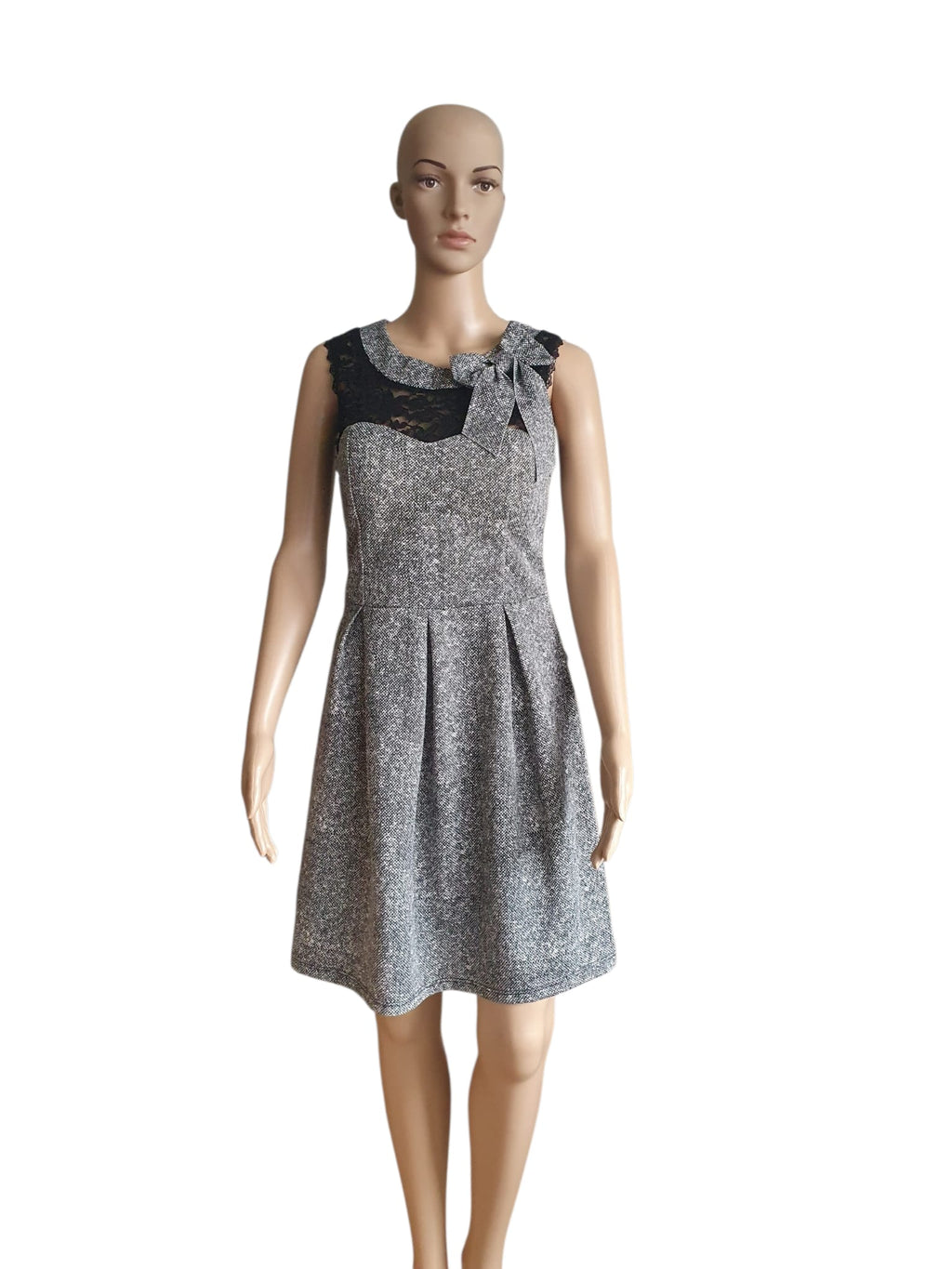 Short A-line skater dress Made in Italy with black lace illusion neckline, tweed pattern, and decorative bow detail.